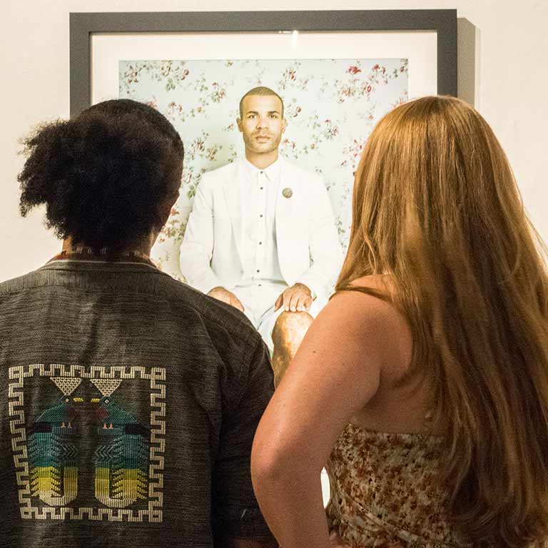 two people looking at painting in gallery